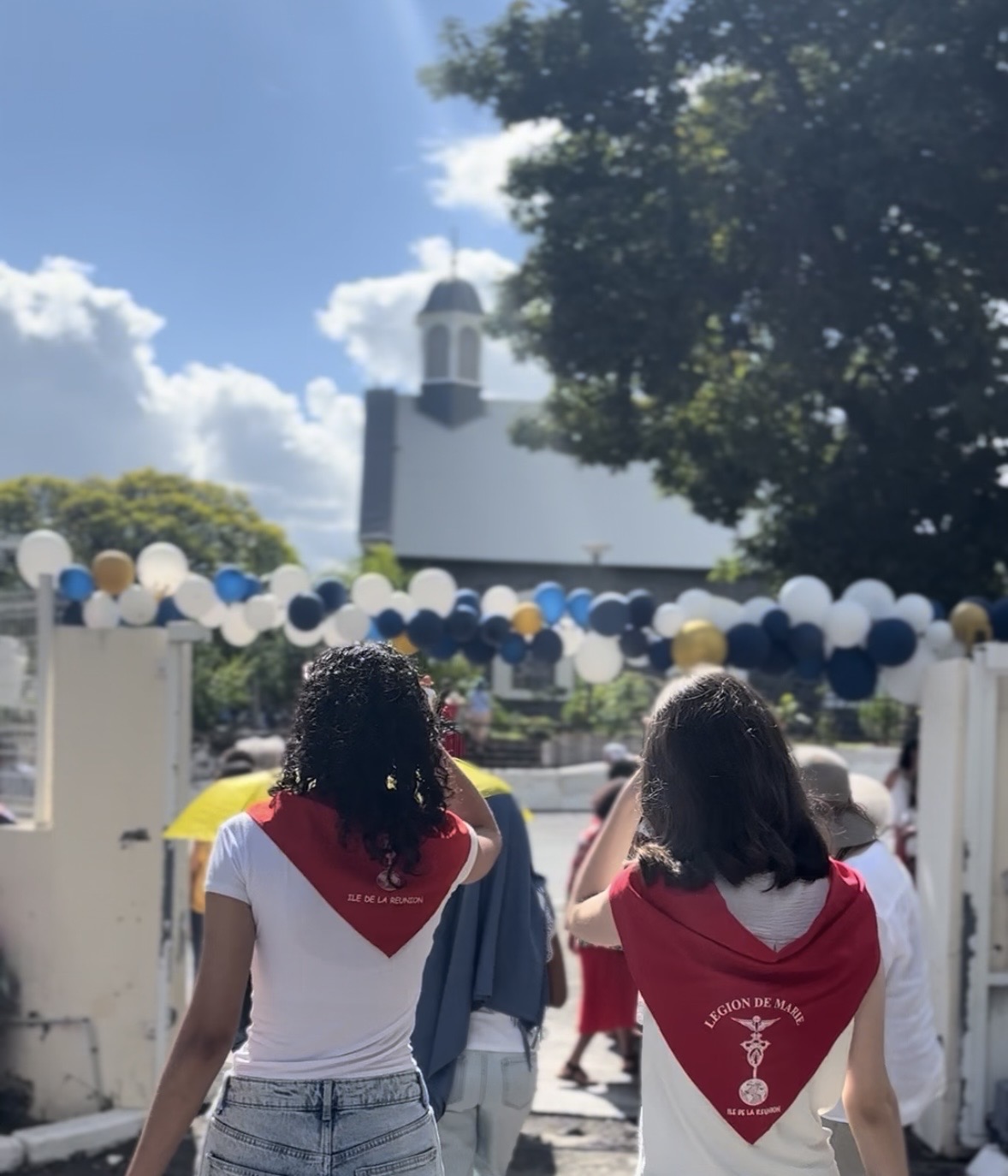 Deux jeunes portant le foulard rouge des Jeunes Légionnaires devant une église